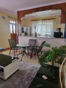 a living room with a table and chairs and a kitchen at G&G Homes WESTINDIES in Eldoret