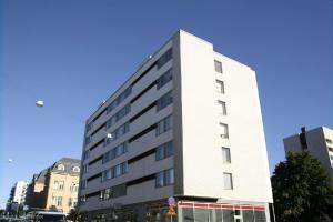 a tall white building on a city street at Central Gem with Sauna - Big two-room apartment FREE PARKING in Tampere