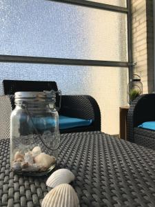 een pot schelpen op een tafel op een patio bij Ferienwohnung Hallix - Wilhelmshaven in Wilhelmshaven