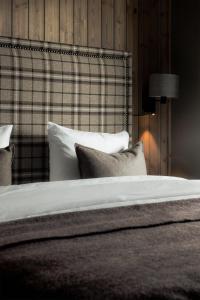 a bedroom with a bed with pillows and a blanket at Highland Lodge Fjellandsby in Geilo