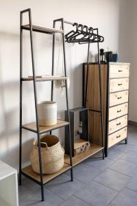 a shelf unit with three tiers next to a dresser at Spazio Ancora appartamento a 500 m. dal mare in Rimini