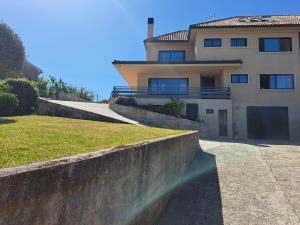 una casa con una pared de retención delante de ella en Playa de la Sirenita, Canido, Vigo, en Vigo