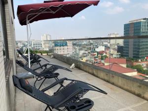 a row of chairs on a roof with an umbrella at Kuretake Inn Kim Ma 132 in Hanoi