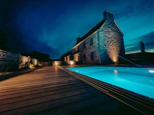 - un bâtiment et une piscine la nuit dans l'établissement Domaine du Mimosa, à Perros-Guirec