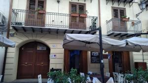 a building with tables and umbrellas in front of it at Cassari UpArtments in Palermo