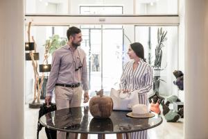 a man and a woman standing next to a table at Avra City Boutique Hotel in Chania