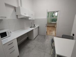 a white kitchen with a sink and a microwave at VasylOk in Warsaw