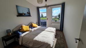een slaapkamer met een bed met gele kussens en een raam bij Float House Nr 659 in Rīga