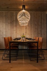 une salle à manger avec une table, des chaises et un lustre dans l'établissement Highland Lodge Fjellandsby, à Geilo