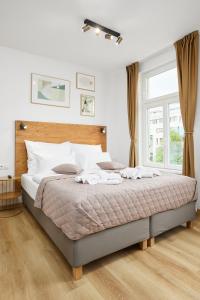ein Schlafzimmer mit einem großen Bett und einem großen Fenster in der Unterkunft Residence 44 in Prag
