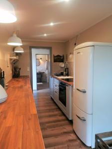 a kitchen with a white refrigerator and a wooden floor at Haus Sandstein Glück Biedermann in Bad Schandau