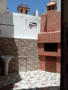 een badkamer met een bakstenen muur en een toilet bij Villa in Oulad Akkou