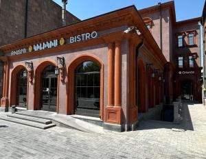a brick building with a bistro sign on it at Orienta Hotel Gyumri in Gyumri