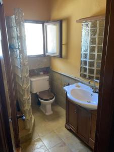 een badkamer met een toilet, een wastafel en een raam bij EL POBLET DE ATALAYAS in Alicante