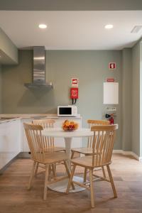 a kitchen with a table with chairs and a microwave at Geonature in Macedo de Cavaleiros