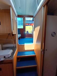mały pokój z drzwiami i schodami w pociągu w obiekcie Traditional 2 bedroom houseboat Nova Natalina w mieście Brovinje