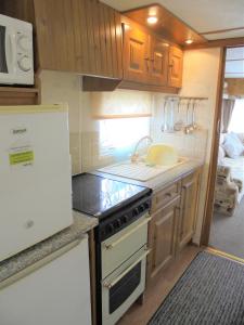 a kitchen with a stove and a sink at Sealands : Arronbrook:- 6 Berth, Access to the beach, Close to site entrance in Ingoldmells