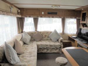 a living room with a couch and some windows at Sealands : Arronbrook:- 6 Berth, Access to the beach, Close to site entrance in Ingoldmells