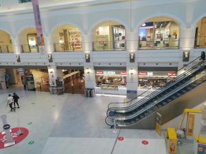 a large shopping mall with escalators and people in it at FIUMARA MALL Apartment in Genoa