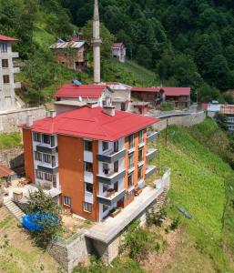 a building with a red roof on a hill at Sağlam Apart Otel in Uzungol
