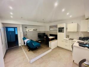a kitchen and living room with a blue chair in it at NaSa Wohnung Uerdingen in Krefeld