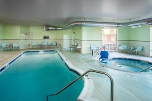 una gran piscina cubierta con sillas y mesas. en SpringHill Suites by Marriott Kennewick Tri-Cities, en Kennewick