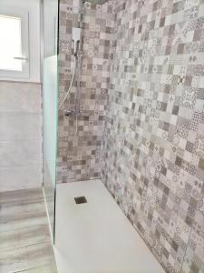 ein Bad mit einer Dusche und einer Fliesenwand in der Unterkunft casa lipa in La Guancha