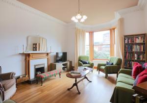 een woonkamer met meubilair en een open haard bij Westend Place in North Berwick
