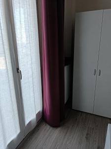 a room with a pink curtain next to a door at Il Castagneto in Trivero