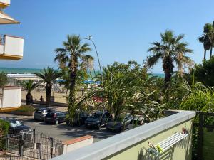 een balkon met uitzicht op een parkeerplaats met palmbomen bij Residence Playa in Tortoreto Lido
