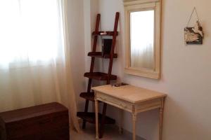 a room with a wooden table and a shelf and a mirror at ALTHEA HOUSES in Alinda