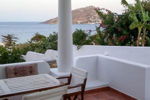 veranda bianca con tavolo, sedie e vista sull'oceano di ALTHEA HOUSES ad Alinda