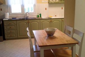 kuchnia z drewnianym stołem z miską w obiekcie ALTHEA HOUSES w Alindzie