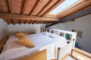 sypialnia z białym łóżkiem i drewnianym sufitem w obiekcie The Chianti Rooster Flat we Florencji