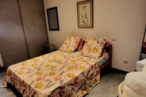 a small bedroom with a bed with a floral bedspread at Magnifique T2 in Ajaccio