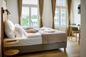 Residence 44 في براغ: غرفة نوم بسرير ومخدات بيضاء ونافذة