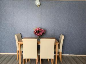 a dining room table with chairs and a vase of flowers at Two Double Bedroom Maisonette with rear garden. 