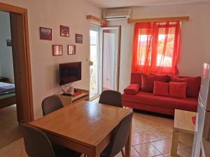 a living room with a red couch and a table at Apartman Katarina in Seget Vranjica
