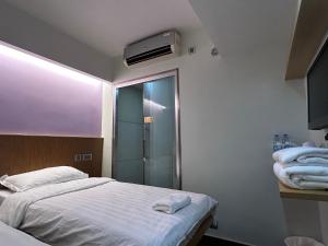 a bedroom with a bed and a walk in shower at i hotel-B&B in Hong Kong