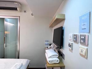 a room with a bed and a tv on a wall at i hotel-B&B in Hong Kong