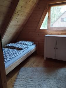 a bed in the attic of a log cabin at morska chata in Lubiatowo