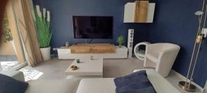 uma sala de estar com um sofá branco e uma televisão em Villa l ÉCRIN au cœur des alpilles em Mouriès