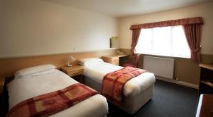 Ένα ή περισσότερα κρεβάτια σε δωμάτιο στο Moreton Park Hotel