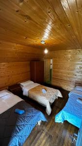 a room with three beds in a wooden cabin at Hotel Tradita Valbonë in Valbonë