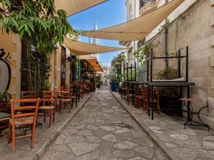 uma rua vazia com mesas e cadeiras num beco em Sanders Palama Limassol em Limassol