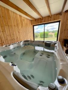 bañera grande en una habitación con ventana en Gite de Carbonade, en Pailloles