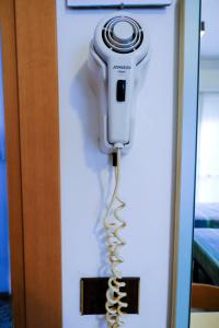 um secador de cabelo pendurado numa parede num quarto em Hotel Chiara em Rimini