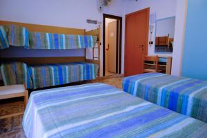 a hotel room with two beds and a hallway at Hotel Chiara in Rimini