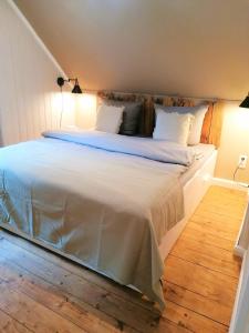 Un dormitorio con una cama grande con sábanas blancas. en Haus Sandstein Glück Biedermann, en Bad Schandau