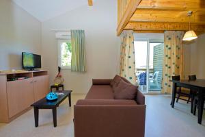 a living room with a couch and a table at Résidence Goélia Les Cottages du Lac in Coly
